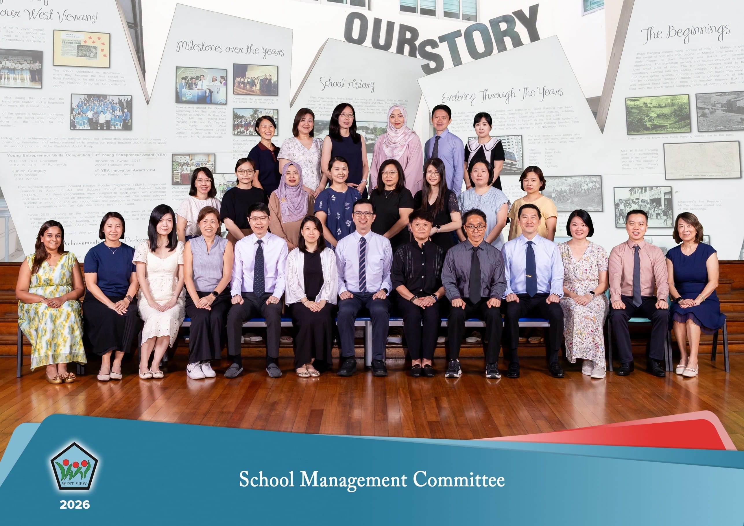 Large group photo of school staff posing with hand hearts and thumbs up; “Vision” and “Values” text behind.